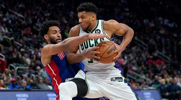 Milwaukee Bucks forward Giannis Antetokounmpo (34) drives on Detroit Pistons’Braxton Key in the first half of an NBA basketball game in Detroit, Friday, April 8, 2022.